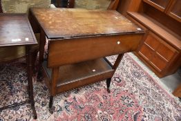 An early mid century tea trolley having atomic style legs with fold out top