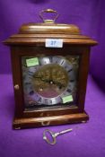 A small bracket mantle clock having brass and similar chased face by Comitti