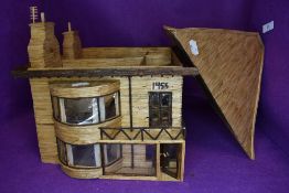 A folk art style dolls toy model house having detailed interior over two floors with furniture