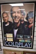 A framed and glazed concert poster for Coldplay with various tickets and stubbs