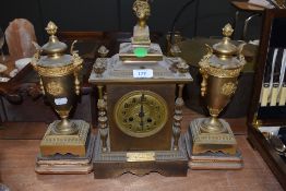 A Victorian brass cased mantle clock and garniture set having extensive ormolu decoration adorned