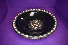 A large terracotta bowl having Islamic design with metal rim and black glaze