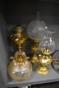 Three antique brass bodied oil burning lamps including etched frosted and lustre glass shades