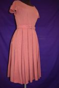 A 1950s rose coloured pleated linen day dress with belt.