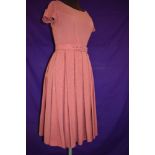 A 1950s rose coloured pleated linen day dress with belt.