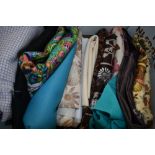 A box full of vintage upholstery and dress fabrics, some large pieces.