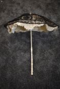 A Victorian parasol having fine black lace over cream tatting and silk ground,white carved handle