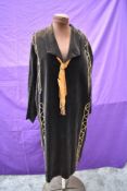 A black velvet 1920s dress having copper thread work and ribbon to neck.