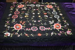 An antique fringed shawl having extensive embroidery and fringing to edges.