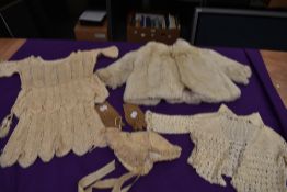 A collection of baby and childrens clothing including fur coat and bonnets, mostly around 1920s.