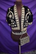 A short velvet bolero or jacket with intricate braid detailing,around 1930s, and a similar bag and