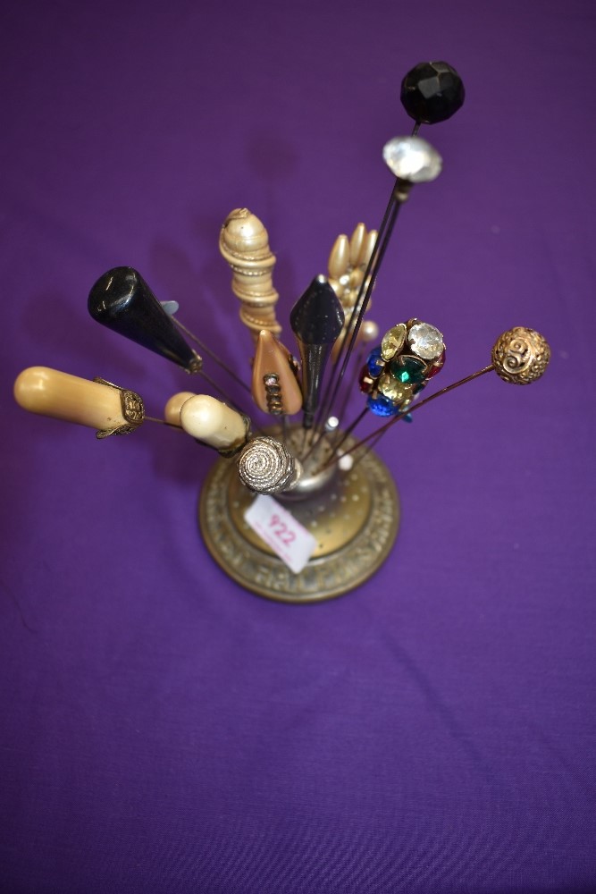 An antique hat pin holder 'Abel Morralls celebrated hat pins' and a collection of hat pins and one