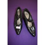 A pair of antique black leather shoes.