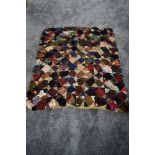 An antique throw or rug using a variety of colourful fabrics.