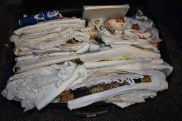 A suitcase containing an assortment of vintage and antique table linen, handkerchiefs, huckaback