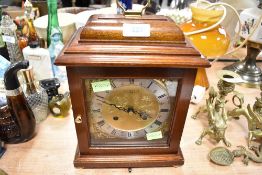 A small bracket mantle clock having brass and similar chased face by Comitti