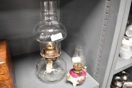 Two oil burning lamps one having a ceramic and printed body