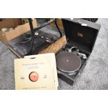A portable gramophone record player by His Masters Voice with 78rpm shellac records