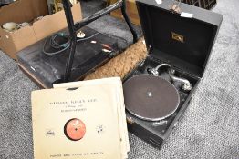 A portable gramophone record player by His Masters Voice with 78rpm shellac records