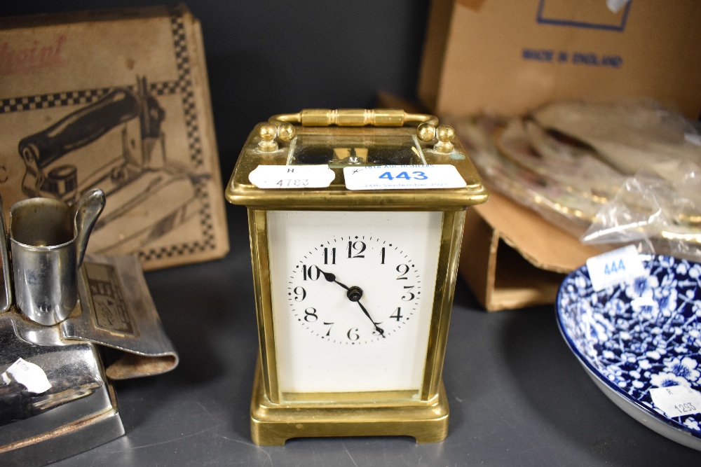 A vintage brass carriage clock having visible escape and enamel face and bevelled glass sides,