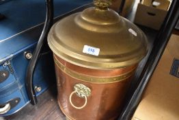 A vintage copper coal bucket with brass fitments and lid