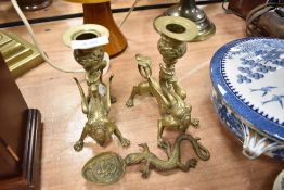 A pair of finely cast mythical dragon form chamber candle sticks and a similar spoon