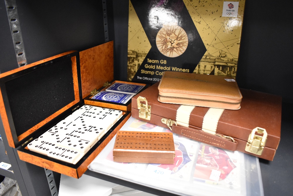 A selection of portable board games including cards dominoes and London 2012 stamp set
