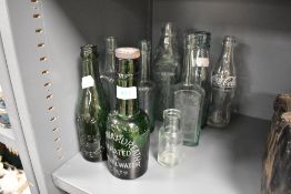 A selection of advertising bottles including Coca Cola, Niblett and mineral water
