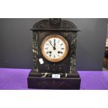 An antique marble mantel clock having roman numerals to enamel face and engraved detailing to