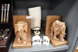 A pair of hand carved book ends decorated with elephant figures and similar ethnic items