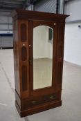 A late 19th or early 20th Century mahogany mirror door single wardrobe