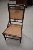 A Victorian stained frame salon chair having later cane seat and back