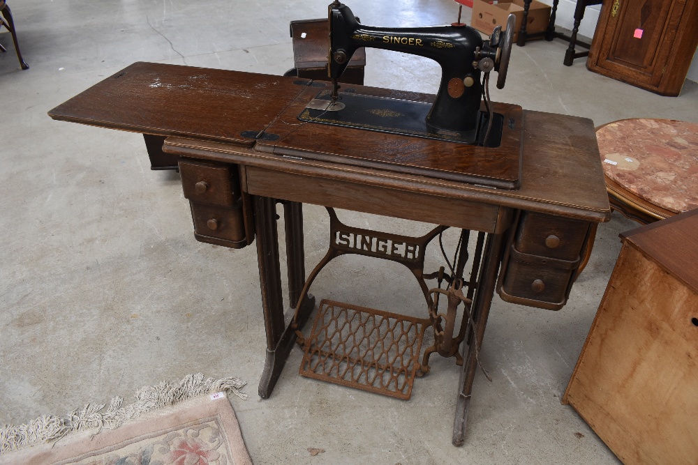 A late 19th or early 20th Century oak cased treadle sewing machine, Singer (serial number) Y7528108