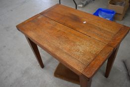 An early to mid 20th Century mid stain oak drawer leaf table with fold over top