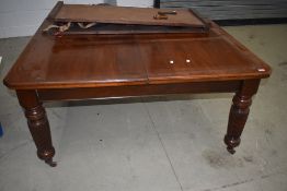 A 19th Century mahogany wind out dining table in the Gillows style, having heavy turned and fluted