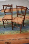 A pair of Victorian mahogany bedroom chairs having cane seats