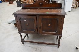 An early 20th Century dark oak sideboard having ledge back, on twist legs, width approx. 106cm