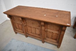 A 19th Century golden oak low sideboard cabinet having panelled doors and sides, fitted with brass