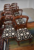 A set of ten Victorian balloon and rail back dining chairs having later modern upholstery