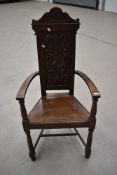 A 19th Century oak carver / hall chair having armorial style back