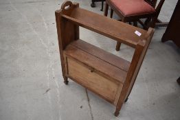 An Arts and Crafts style booktrough/shelf with double sided compartments under, width approx. 57cm