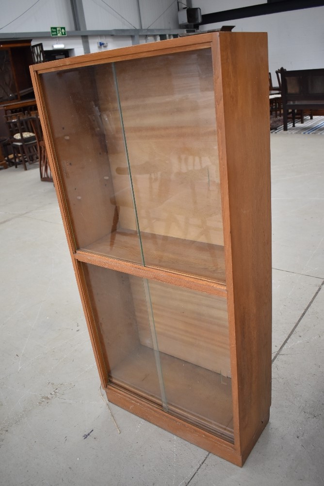 A vintage golden oak glazed bookcase, single piece double height