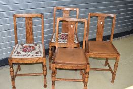 A set of four early to mid golden oak dining chairs, two having tapestry seats