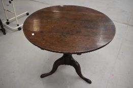 A 19th Century oak pedestal table having circular snap top (diameter approx. 86cm) turned column and