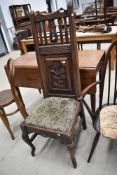 A 19th Century oak hall or dining chair having rail and carved panel back and moquette upholstered