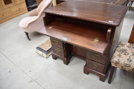 A hardwood kneehole desk in the 19th Century style having pull out desk to frieze