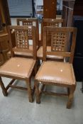 A set of four golden oak lattice back dining chairs by Mouseman, some damage to legs