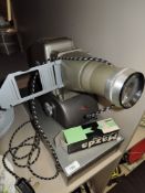 A vintage Aldis projector and metal case containing slides.