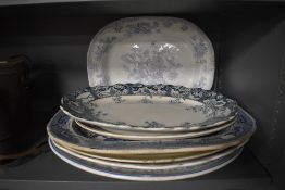 A selection of antique and later meat platters and serving dishes including blue and white wears