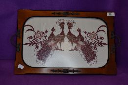 A vintage butlers tray decorated with needle work peacocks